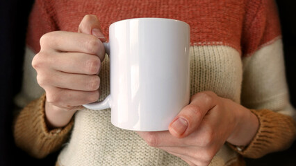 Woman hand holding white tea cup. Ceramic coffee cup mock up. 