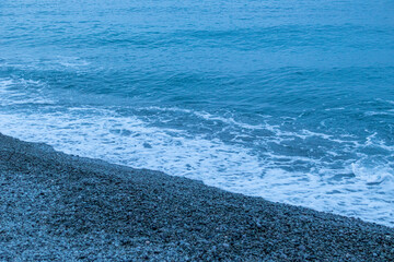 beautiful, blue sea with waves, beach, rocks in the evening on a nice, warm evening in travel