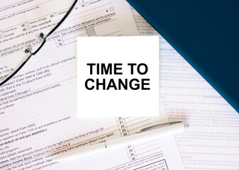 Tax form with business card with text Time To Change. Notepad, eyeglasses and white pen