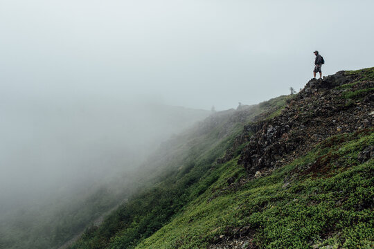 Man Standing on Misty Mountainside