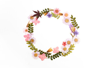 Fototapeta na wymiar Wreath made from dry leaves and flowes on white background. Dry flowers frame. Flat lay.