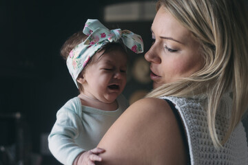 mum comforts her baby as she cries