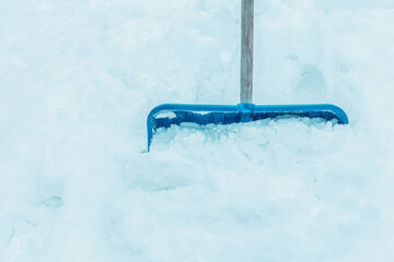 Snowy winter - blue shovel in a large pile of snow (snowdrift) - background