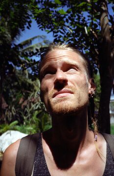 Young man squinting at the sun