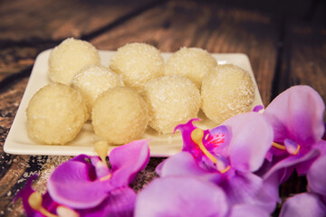 sweet candies on a wooden background with a flower