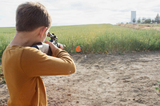 boy aims bb gun at target