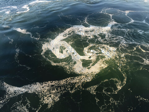 Swirling water and foam from waves and surf