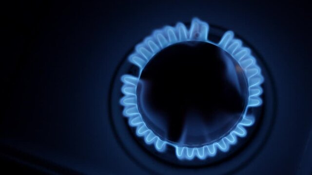Kitchen burner turning on. Stove top burner igniting into a blue cooking flame. Natural gas inflammation, close up.