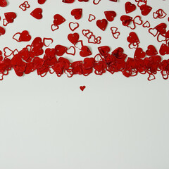 A red heart shaped confetti border with copy space.
