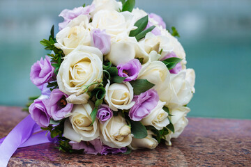 Beautiful wedding bouquet of natural flowers on a blurred background lies on granite