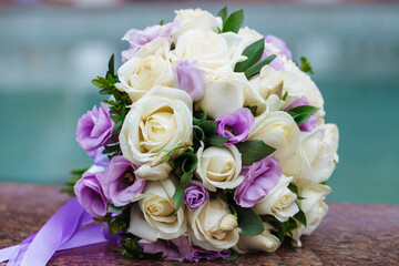 Beautiful wedding bouquet of natural flowers on a blurred background lies on granite