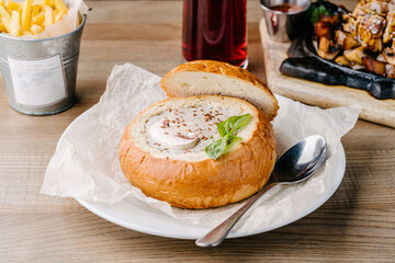 homemade mushroom soup in a bread bowl on a table in a cafe