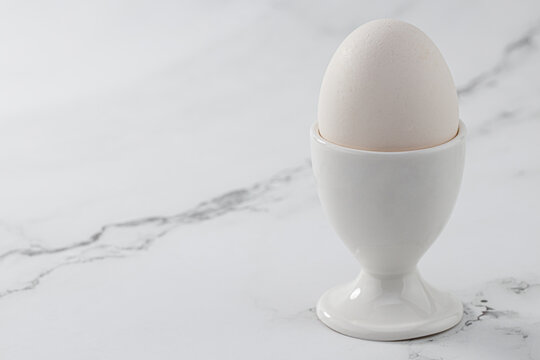 boiled egg in eggshell in egg holder with copy space