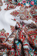 top view closeup on crumpled white cotton scarf with colorful oriental ornament