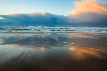 Sunset reflections on the beach with storm