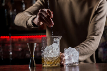 Barman make alcohol cocktail at bar counter. Barman making Jungle Juice coctail in bar