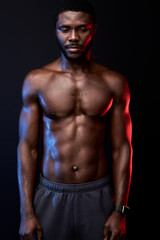 Fototapeta na wymiar black man with naked torso posing at camera while posing shirtless isolated in studio on black background, he is looking down. sport, workout, bodybuilding concept