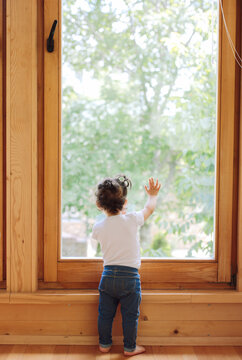 Little girl looking through wndow