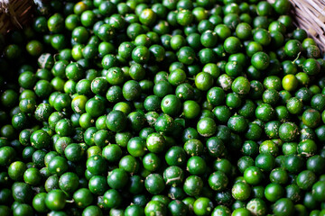 Calamansi in basket. A lot of tropical citrus fruits at market