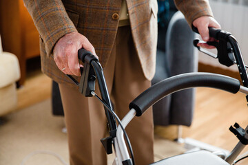 Elderly man using a walker to get around the house