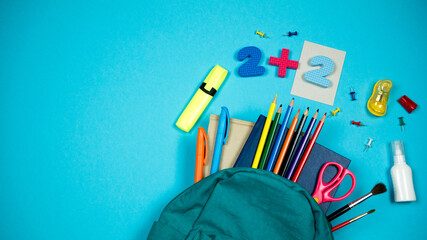 Fully filled school backpack on a bright background. Place for text on the left 