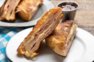 Ham and melted cheese sandwich called Monte Cristo on wooden background