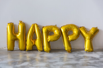 Gold balloons that spell the word 'HAPPY'