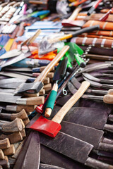 Different axes and knifes at street market. Outdoors marketplace