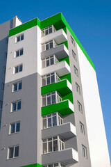 Bottom view of modern residential building against a blue sky.  Vertical image. 