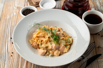 Salmon pasta with capers and creamy sauce in white wide dish
