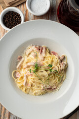 Classic carbonara spaghetti with grated parmesan close up, juicy yummy shot