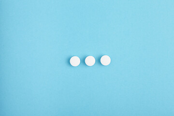 Closeup of white pills on a blue background. Heap of pills - medical background