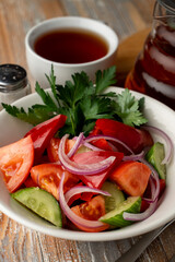 Simple vegetable summer salad with pink tomatoes, crunchy cucumbers and onion