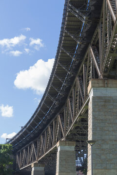 Curve of large steel and masonry bridge structure with patchy cl