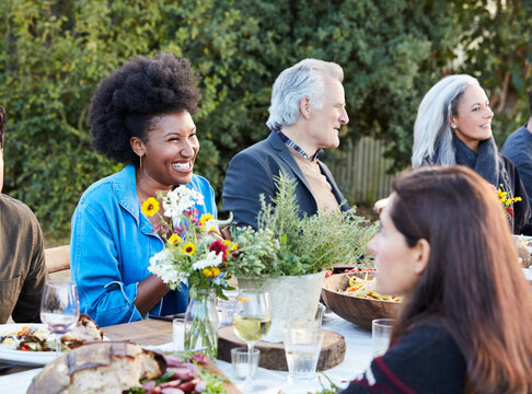 Group of friends enjoying a Farm To Table Dinner Party in backyard