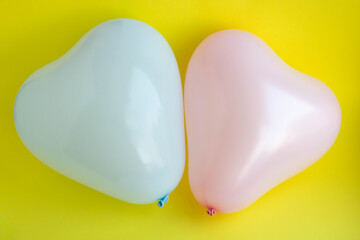 Blue and pink balloons in the shape of a heart on a yellow background. Wedding concept, Valentine's Day, photo zone, lovers. Banner. top view.
