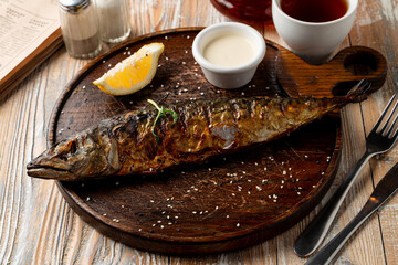 Whole grilled freshwater fish with head, food magazine photo for recipe wooden background