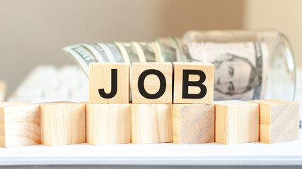 JOB word written on wooden blocks. American currency. Money and financial concept.