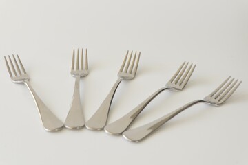 Five pastry forks isolated at a gray background