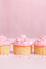 homemade vanilla cupcakes with pink buttercream frosting and heart sprinkles 