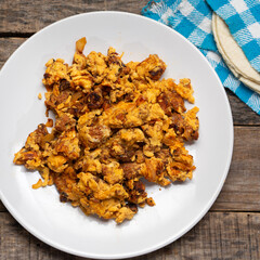 Scrambled eggs with chorizo for breakfast on wooden background. Mexican  food