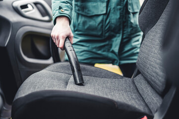 Woman hoovering a car cabin. Vacuum cleaning car seats interior..