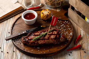 Man meal: a loin steak with grill traces on it with with roasted corn side, pub atmosphere