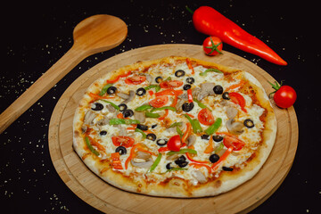 Vegetarian pizza with vegetables on wooden plate. Promotional pizza background.