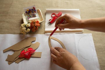 Women's hands transfer the pattern pattern of the toy to the fabric. Needlework, hobbies, creativity.