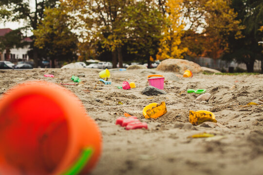 Playground sandbox left littered with toys.