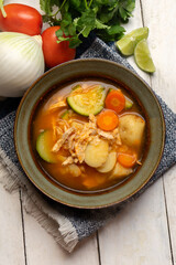 Chicken soup with rice and vegetables on white background