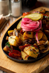 Close up of potato and meat stew with herbs and onion in a cast-iron, comfort food