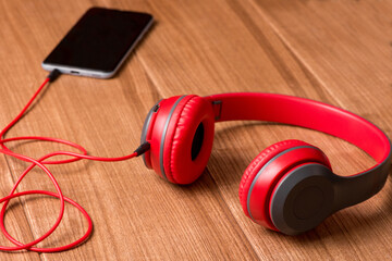 Smartphone and headphones on a rustic wooden table. Top view with copy space