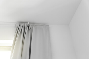 Grey color of curtains in room with white part of wall